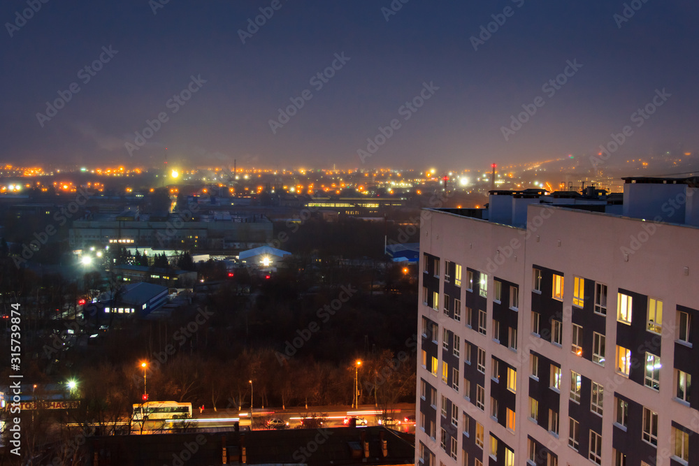 Fototapeta premium Evening arial view of a high-rise modern building with flickerin