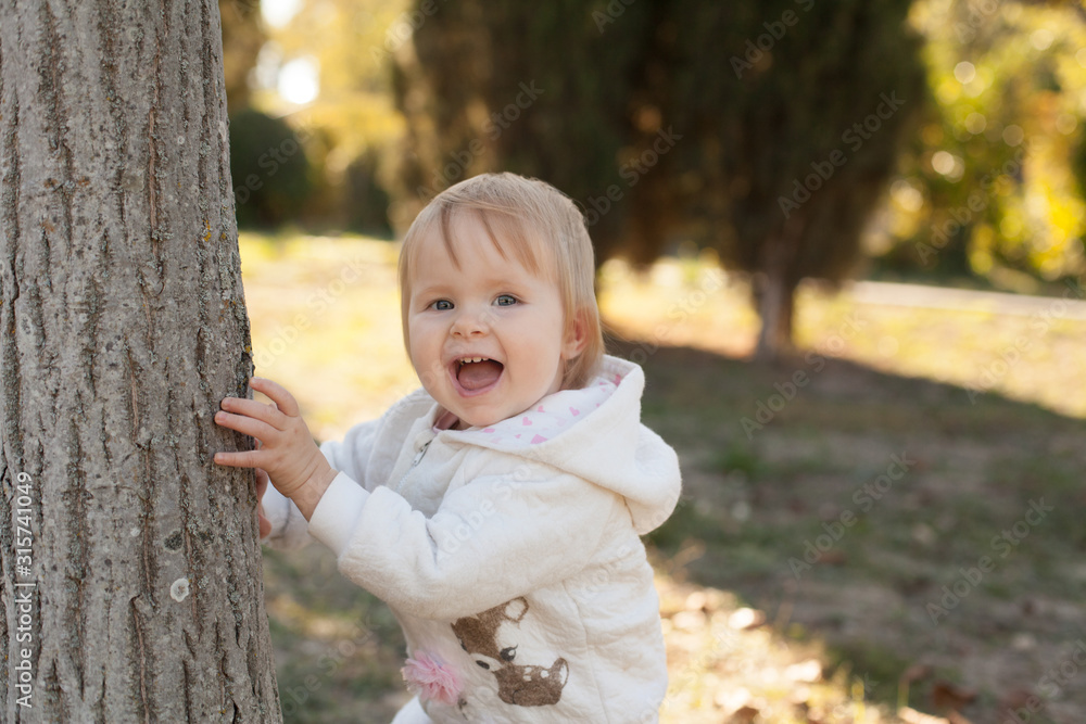 Cheerful funny child smiling in nature in the beautiful rays of the sun. Concept: family relationships, caring for babies. Cheerful funny child smiling in nature in the beautiful rays of the sun. Concept: family relationships, caring for babies.