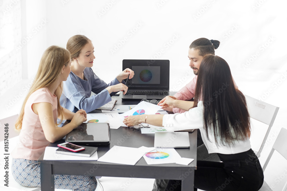 A group of colleagues communicate in the workplace. The concept of entrepreneurs, making money and work. A group of colleagues communicate in the workplace. The concept of entrepreneurs, making money and work.