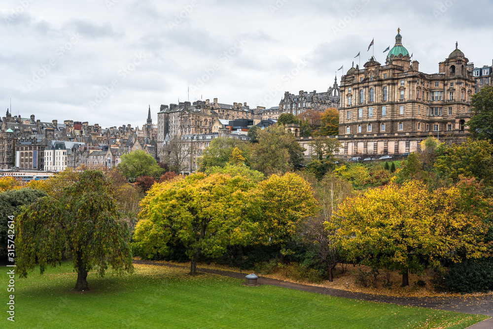 Obraz premium Edinburgh old town skyline with a park in foreground on a cloudy autumn day