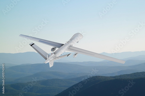 Spy unmanned aerial vehicle (UAV) flies over low mountains in mist