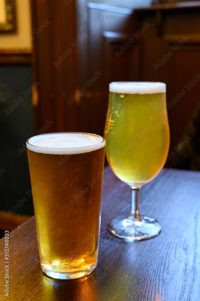 Misty glasses with two pints of cold Scotch ale, amber pale ale, lager draft beer in English pub Misty glasses with two pints of cold Scotch ale, amber pale ale, lager draft beer in English pub