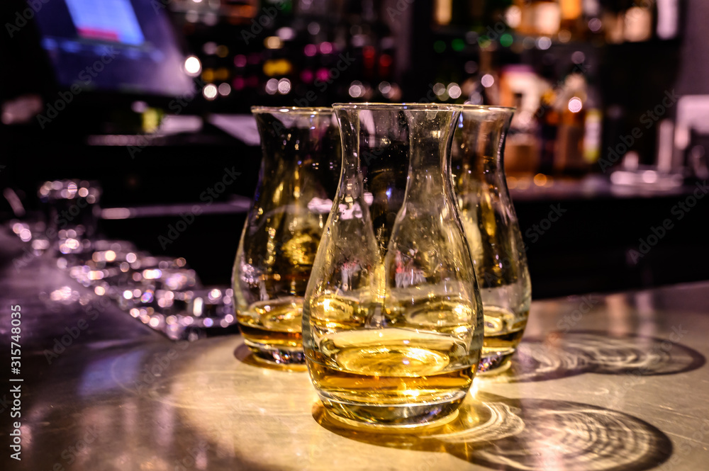 Scotch whisky, tasting glasses with variety of single malts or blended whiskey spirits on distillery tour in Scotland Scotch whisky, tasting glasses with variety of single malts or blended whiskey spirits on distillery tour in Scotland