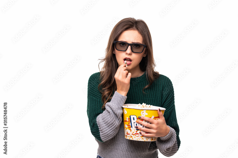 Young pretty woman in stereo glasses holding popcorn and posing in surprise on white background. Young pretty woman in stereo glasses holding popcorn and posing in surprise on white background.