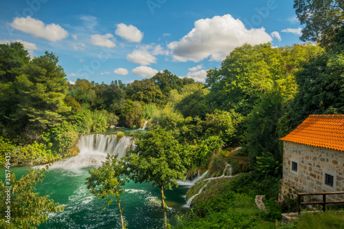 Waterfall and old stone house in Krka National Park, Croatia. House next to Krka waterfall.