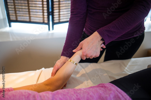 A wellness practitioner treats a client for pain