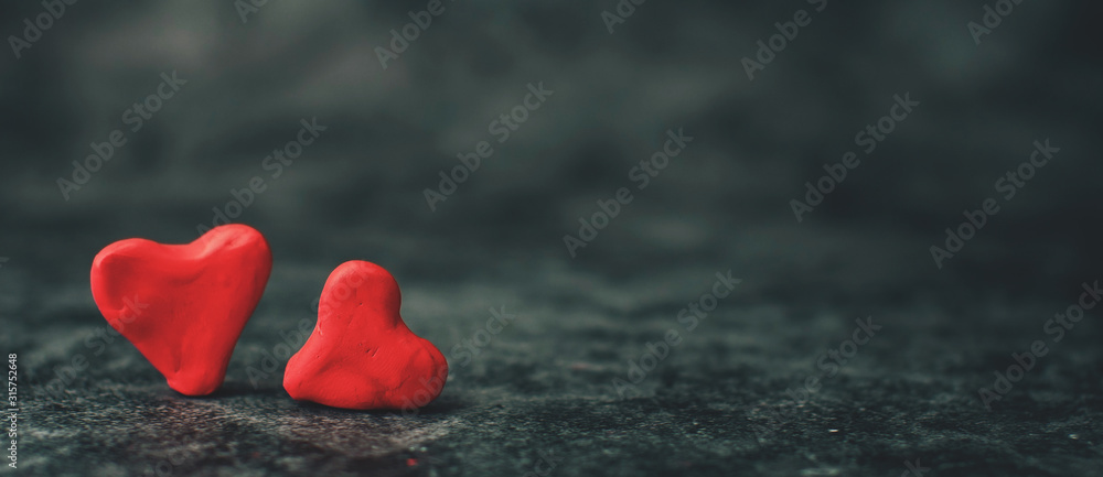 Fototapeta premium Festive background for Valentine's Day on a gray cement background with hearts in retro style from plasticine.