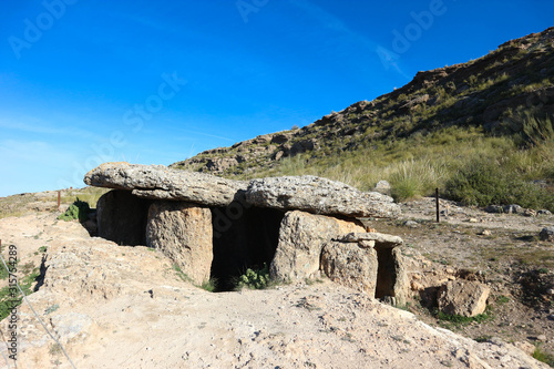 Ancient megalithic burial construction dolmen in Gorafe badlands, Spain under blue sky