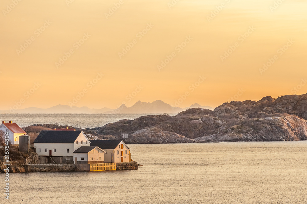 wood house with amazing sunset in background in lofoten, norway.