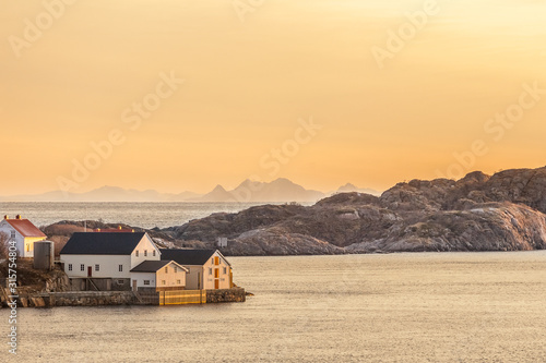 wood house with amazing sunset in background in lofoten, norway.