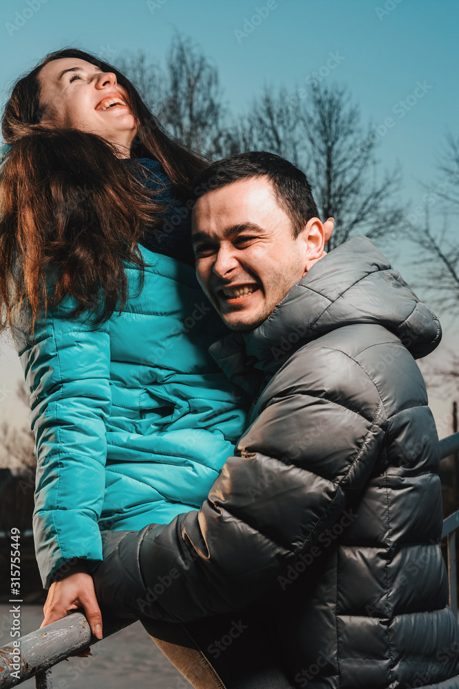 Young beautiful loving couple walking in city park near lake on valentines day. Young beautiful loving couple walking in city park near lake on valentines day.