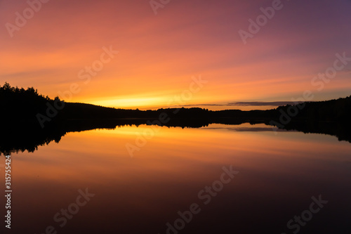 Peaceful orange, yellow and purple sunset over calm lake