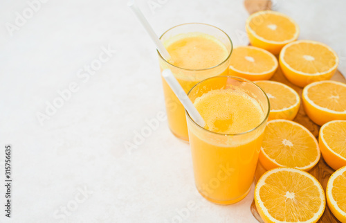 Glass of freshly squeezed orange juice and slices of orange fruit isolated on white background
