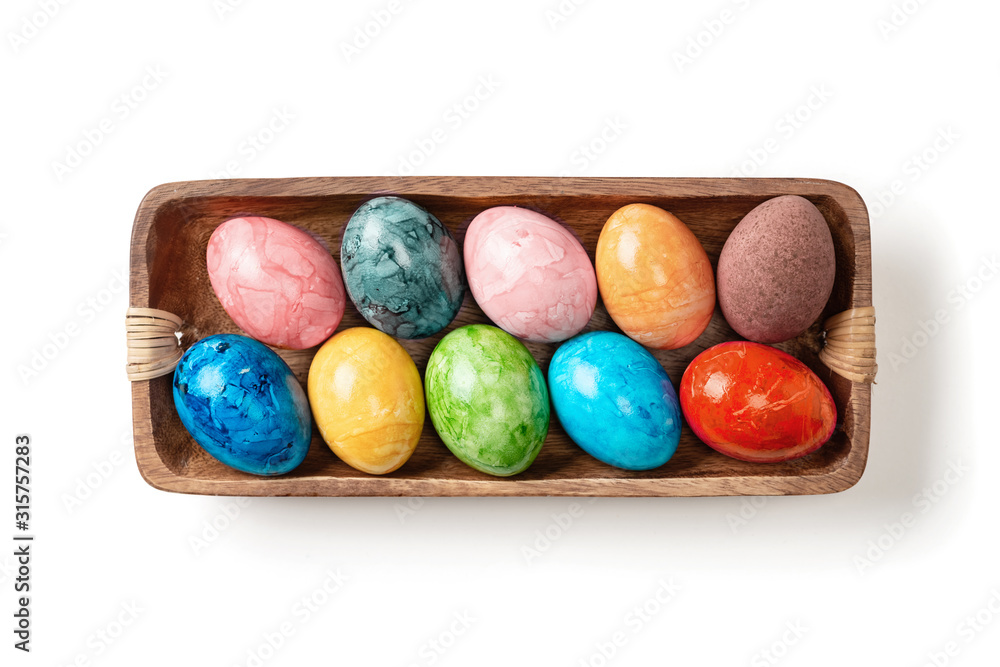 Different easter eggs in wooden bowl isolated on white Different easter eggs in wooden bowl isolated on white