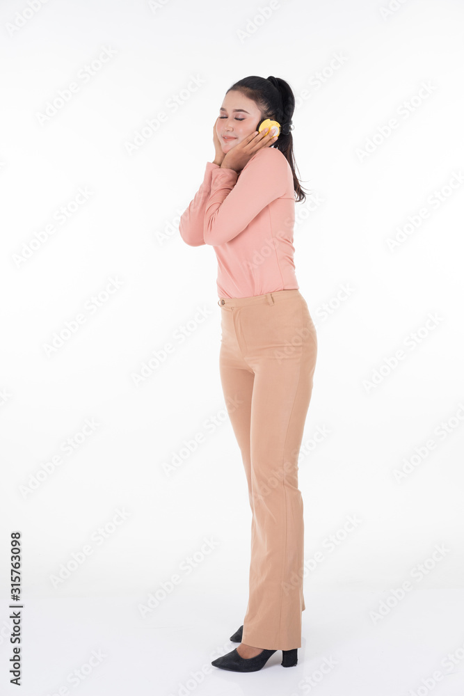 Cheerful Asian teenager wearing turtleneck and pants using wireless headphones enjoying listening to music studio portrait shot isolated on white background. Easy to cut out. Portrait orientation. Cheerful Asian teenager wearing turtleneck and pants using wireless headphones enjoying listening to music studio portrait shot isolated on white background. Easy to cut out. Portrait orientation.