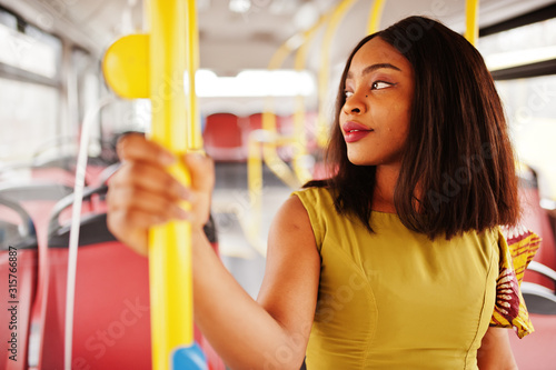 Young stylish african american woman riding on a bus. photo