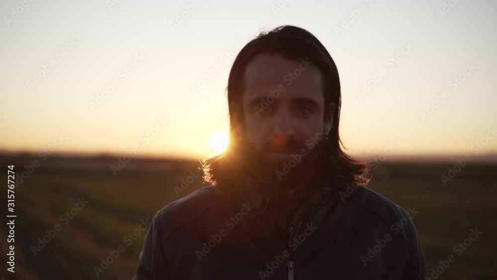 Man standing in middle of field and looking at camera Man standing in middle of field and looking at camera