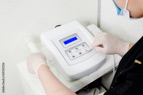 beautician in white gloves  preparing ultra peel and  pdt led instrument for anti-aging treatments and photo rejuvenation procedure in beauty 