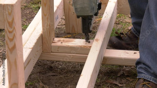 Pneumatic nail gun putting nails in boards with sound