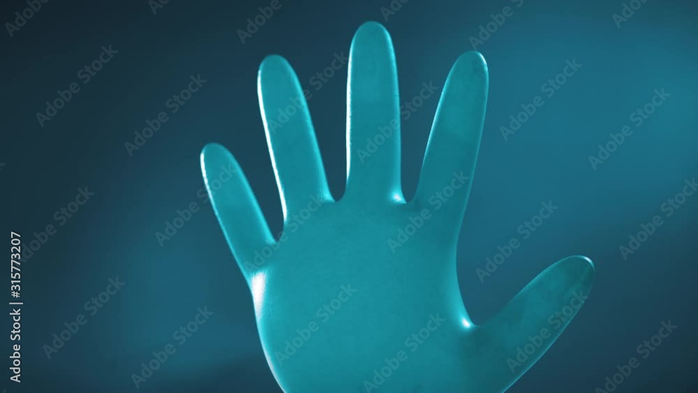 A blue latex glove rotates on a blue background. Means of protection and hygiene. Rubber glove close-up A blue latex glove rotates on a blue background. Means of protection and hygiene. Rubber glove close-up