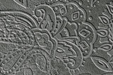Texture of genuine leather with embossed floral trend pattern close-up, color, for wallpaper or banner design. Fashionable modern background
