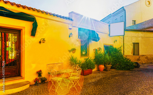 Fototapeta Naklejka Na Ścianę i Meble -  Restaurant in Corso Umberto I Street at Old city of Olbia on Sardinia Island in Italy. Tourists at cafes with tables in Town on Italian Sardegna. Mixed media.