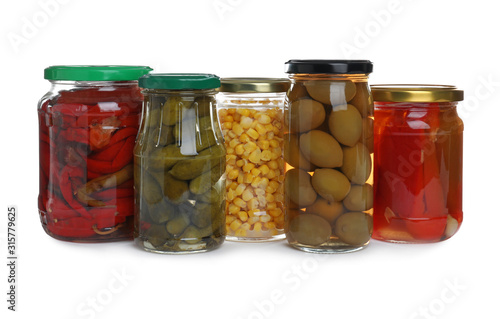 Glass jars of different pickled vegetables isolated on white