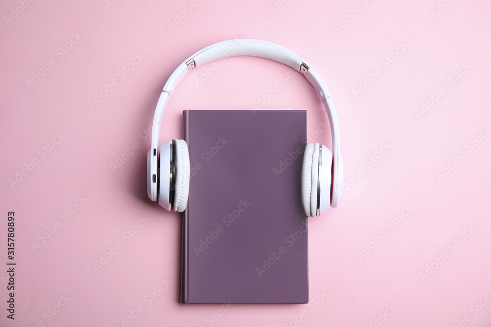 Book and modern headphones on pink background, top view - obrazy, fototapety, plakaty 