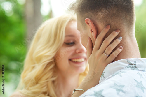 The guy with the girl hugs and kisses. A romantic date in a pine forest, love couple of a lovely couple