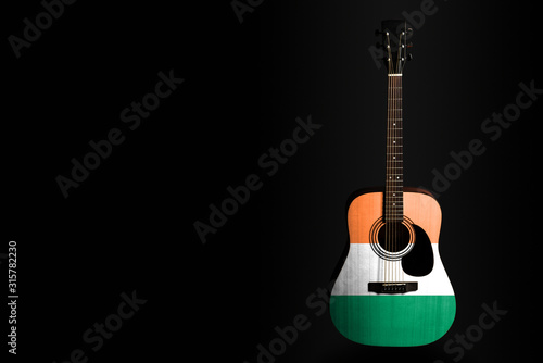 Photography Acoustic concert guitar with a drawn flag Ireland, on a dark background, as a symbol of national creativity or folk song