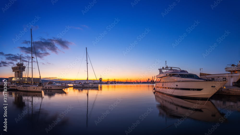 Yacht port and beautiful sunset over Varna, Bulgaria. Sailboat harbor, many beautiful moored sail yachts in the sea