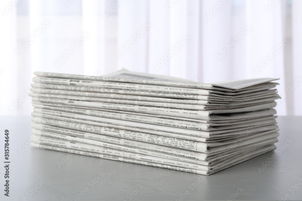 Stack of newspapers on light grey table. Journalist's work Stack of newspapers on light grey table. Journalist's work