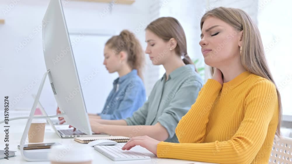 Young Creative Woman working on Desktop and having Neck Pain Young Creative Woman working on Desktop and having Neck Pain