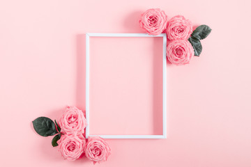 Beautiful flowers composition. Blank frame for text, pink rose flowers on pastel pink background. Valentines Day, Easter, Birthday, Happy Women's Day, Mother's day. Flat lay, top view, copy space