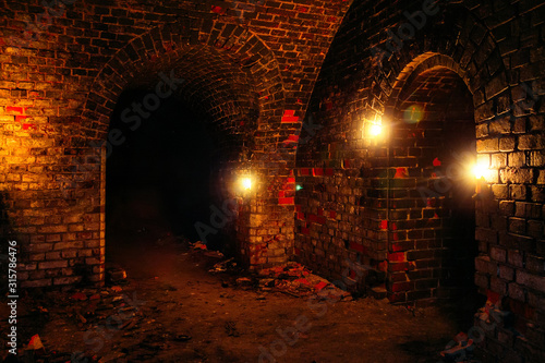 Dark dungeon under the old german fortress illuminated by candles