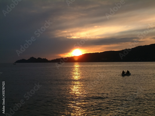 Sunset over promontory Portofino with boats at sea