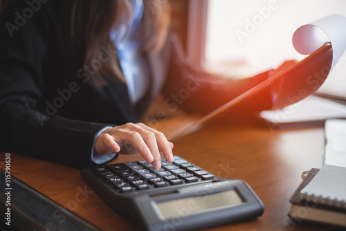 Close up of female accountant or banker making calculations. Savings, finances and economy concept
