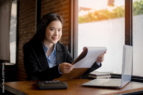 Successful business woman working at the office looking at camera