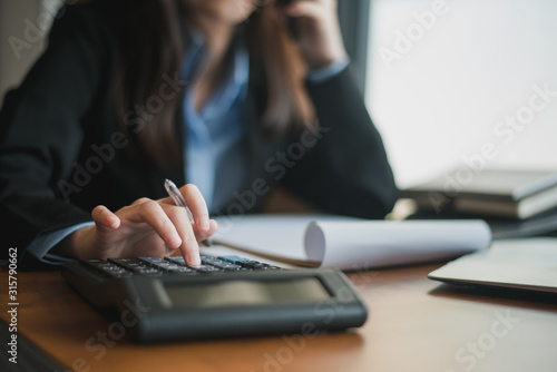 Close up of female accountant or banker making calculations. Savings, finances and economy concept