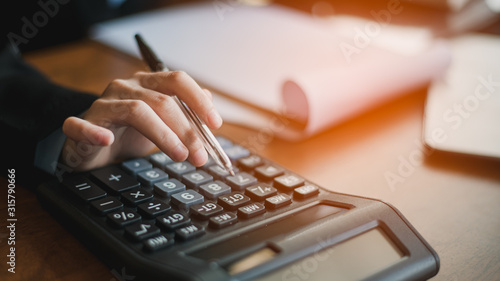 Close up of female accountant or banker making calculations. Savings, finances and economy concept