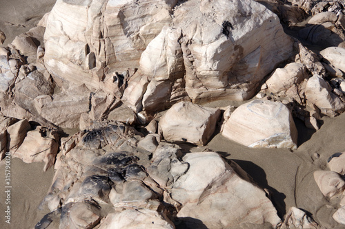 Close-up full frame view on some large rocks on a California beach with traces from an old fire pit