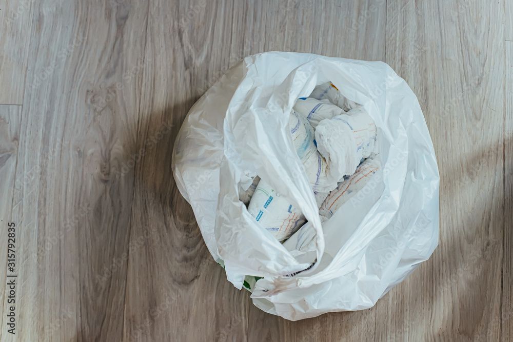 Disposable polyethylene bag with used diapers. Dirty, excrementstained