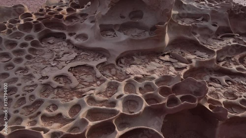 Pan right close up of tafoni formations in a clay pan in Namibia. photo