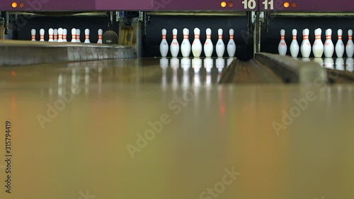 A pinsetter sets pins at a bowling alley, low angle photo