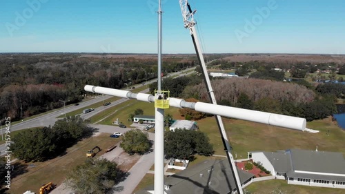 Communications Technicians Installing Cross Shaped Cell Phone Tower photo