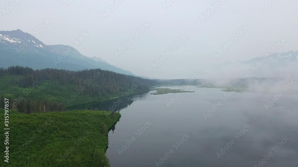 Flying over a foggy lake and green forest Flying over a foggy lake and green forest