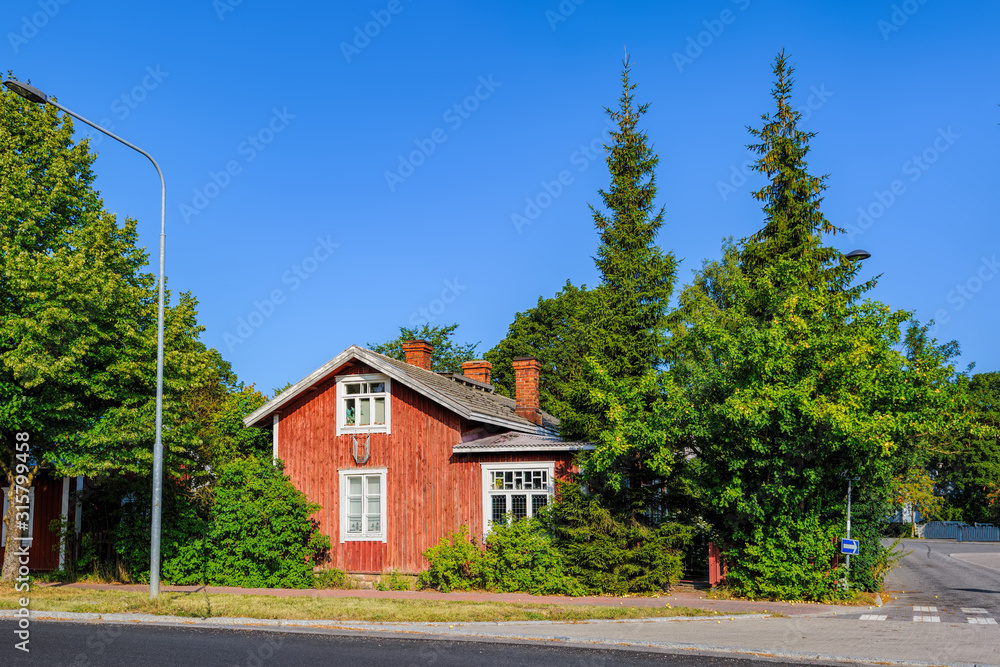 Traditional wooden house painted in traditional falun red with white window at street of Pargas town (Parainen in Finnish) in Finland at sunny summer day.