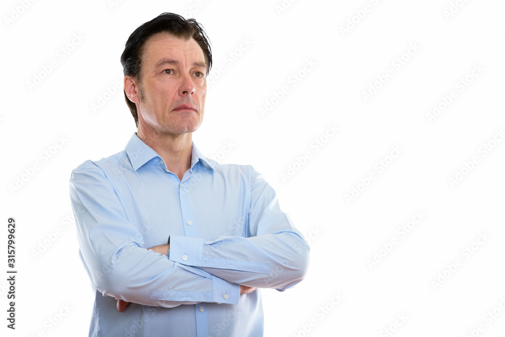 Studio shot of mature handsome businessman thinking with arms crossed Studio shot of mature handsome businessman thinking with arms crossed