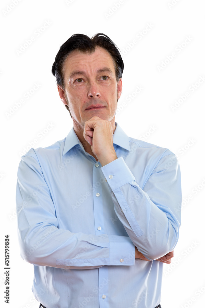 Studio shot of mature handsome businessman thinking while looking up Studio shot of mature handsome businessman thinking while looking up