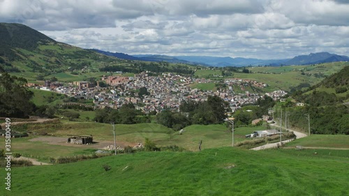 Timelapse of picturesque wide view of rural landscape and the village of La Calera (close to Bogota), in Colombia, South America, clouds moving over green pastures, mountains, valley and houses photo